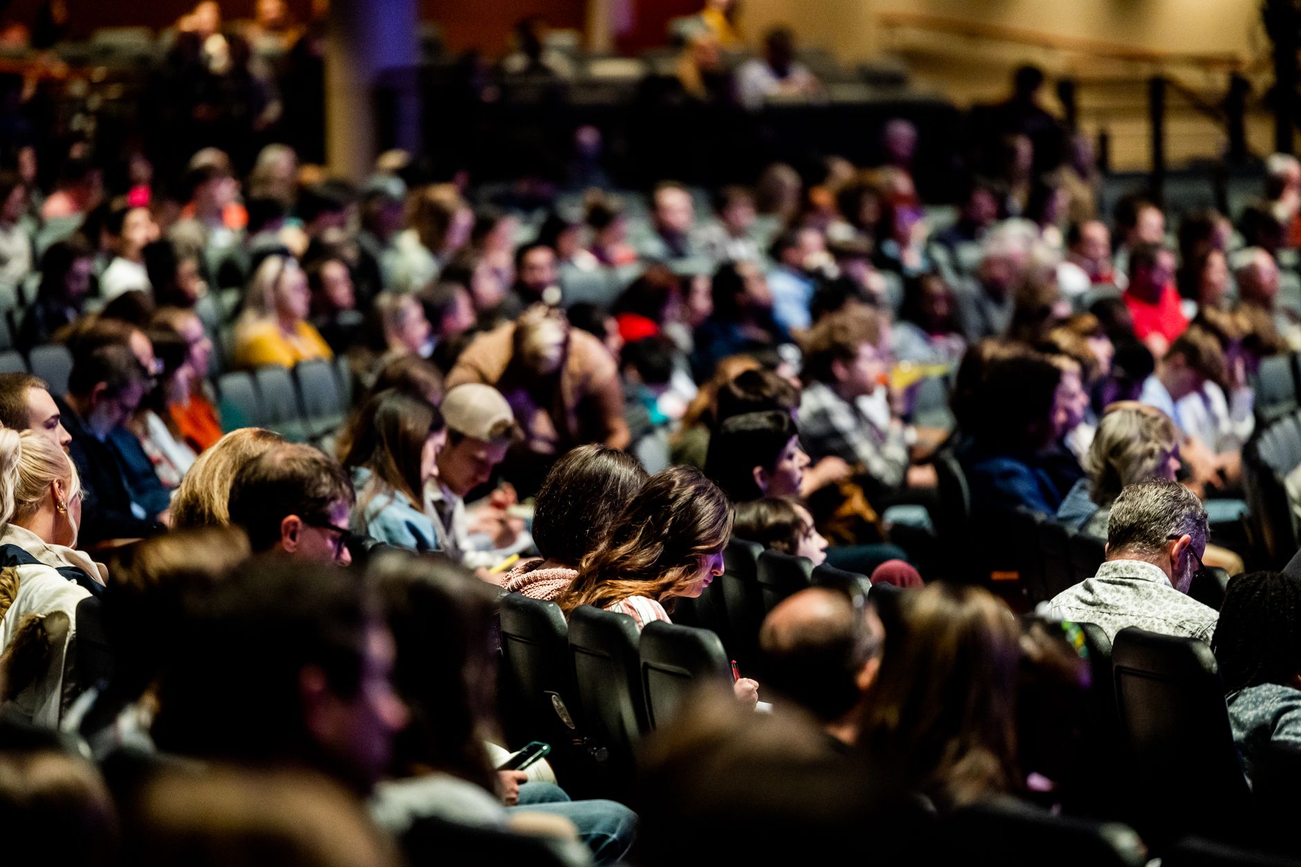 Rows of seated attendees at an indoor public meeting