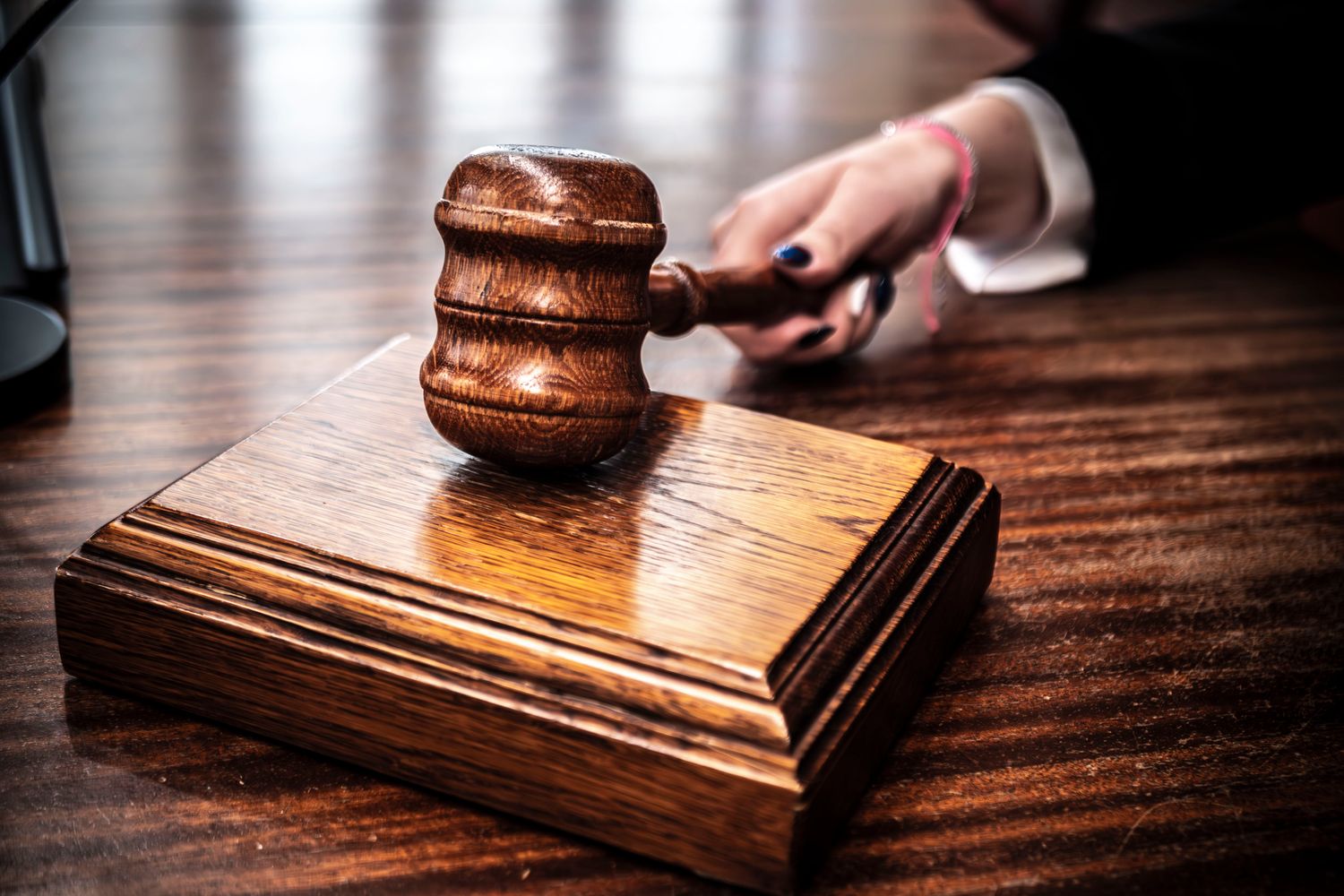 Wooden gavel resting near legal books on a desk