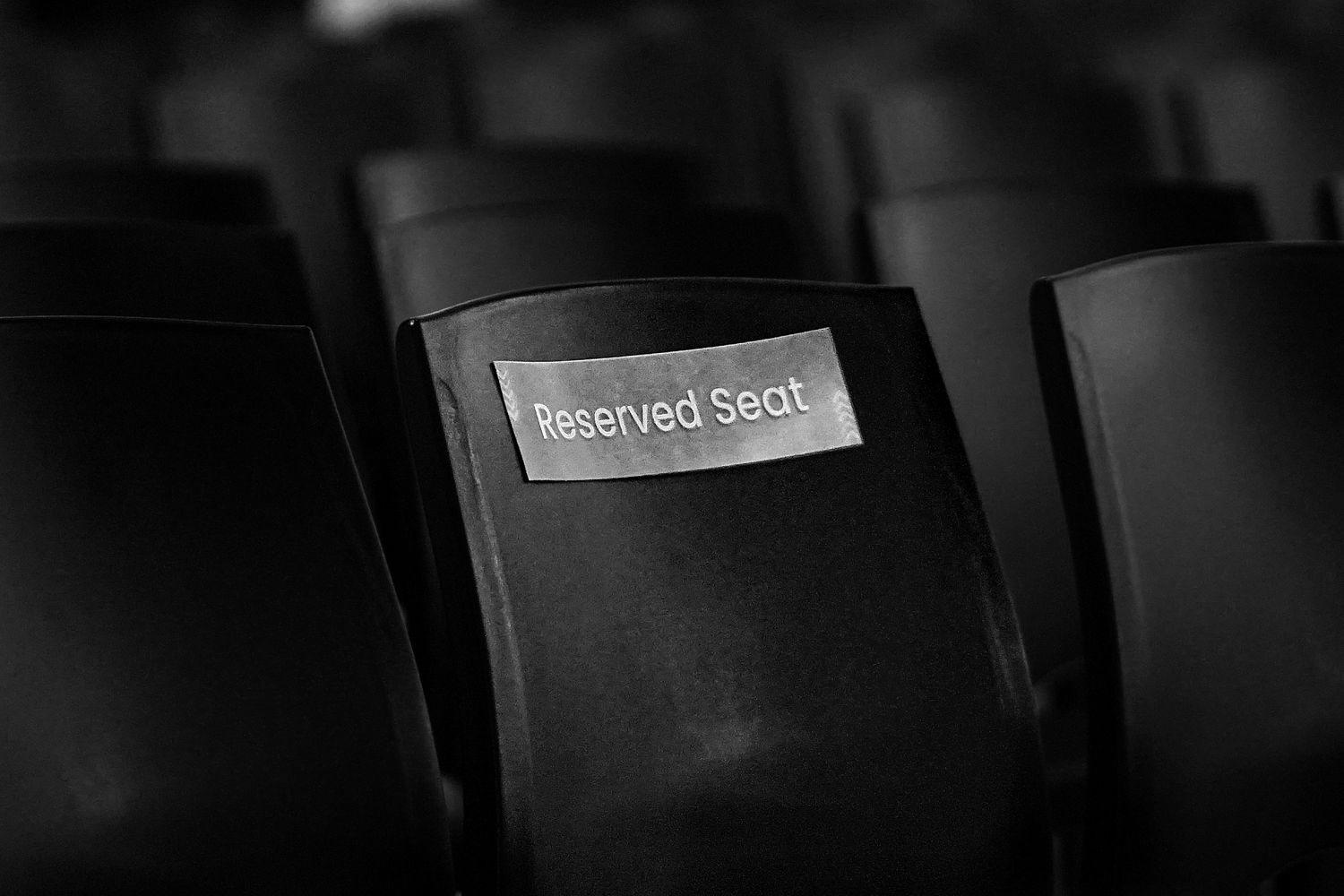 Rows of empty folding chairs in an event space with no attendees