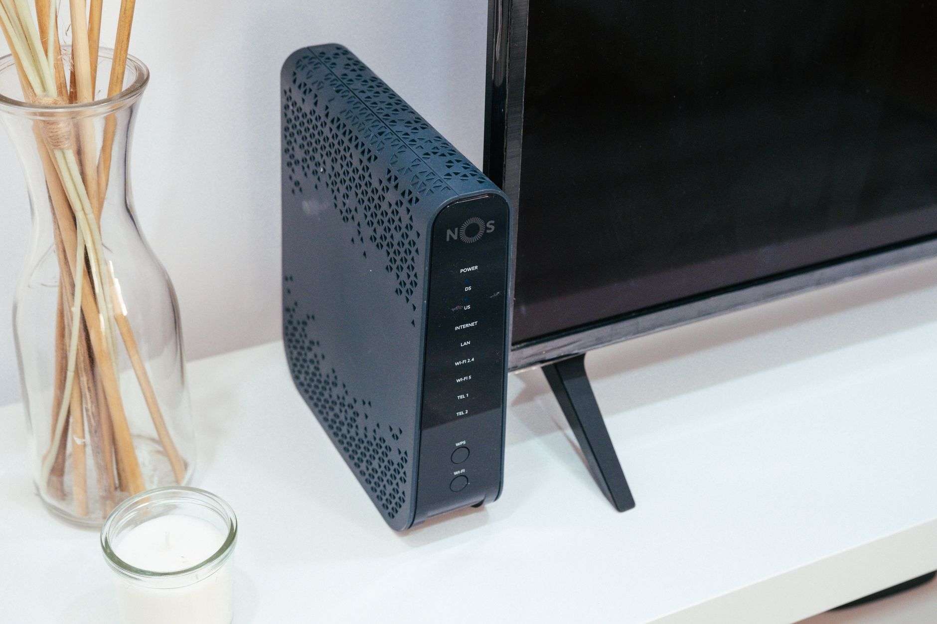 A home internet router with indicator lights on a table