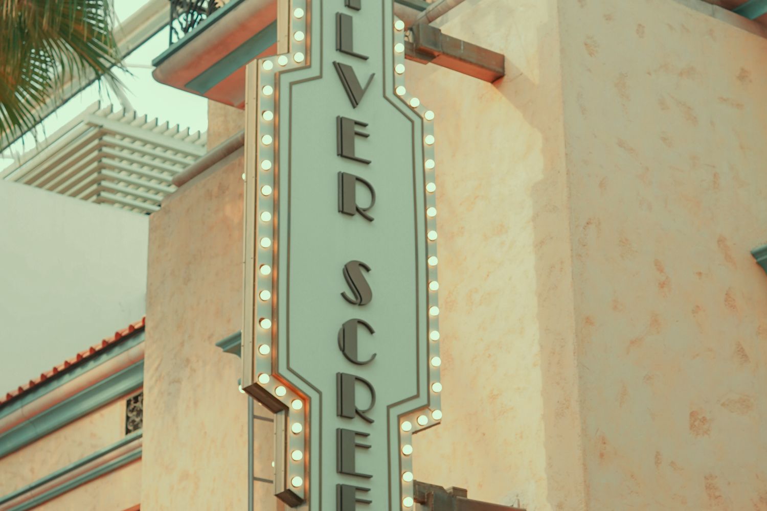 The illuminated marquee of a small independent movie theater in the evening