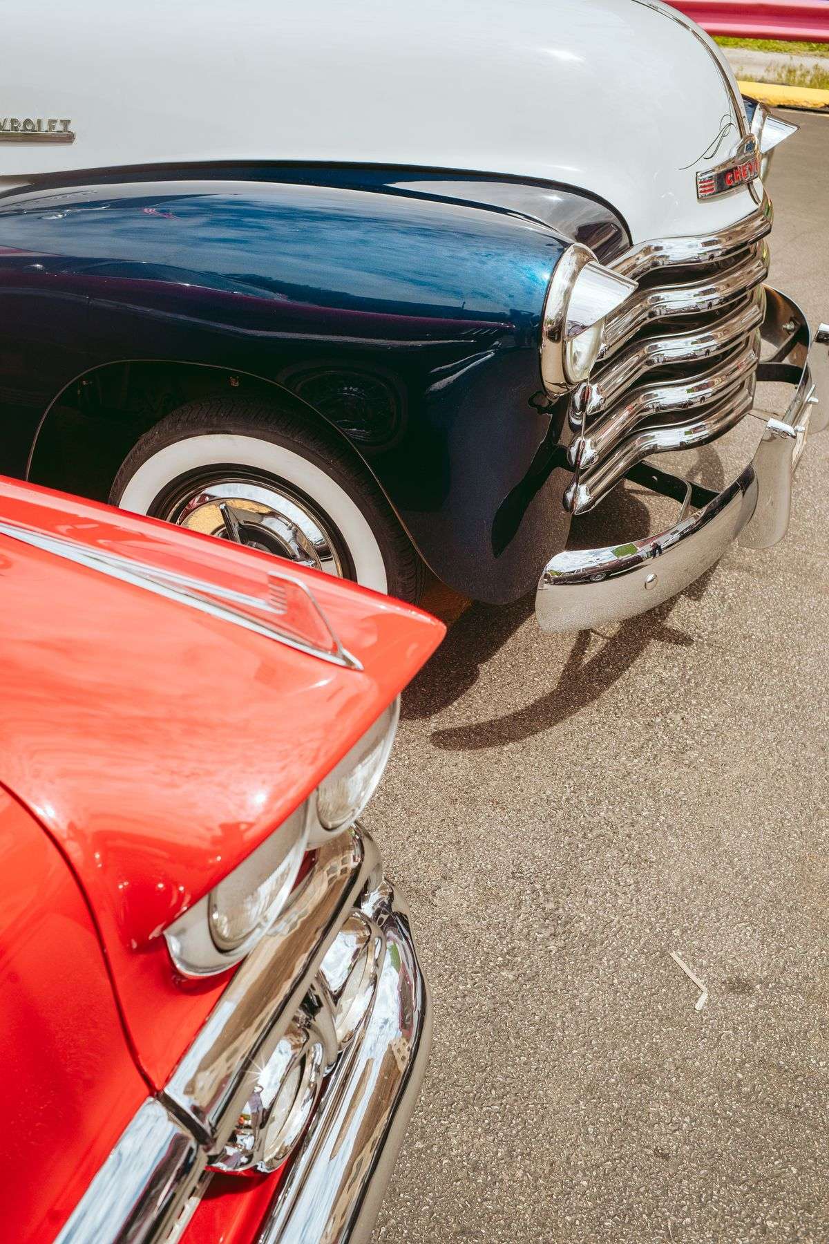 Custom cars and trucks parked in rows at an outdoor car show event