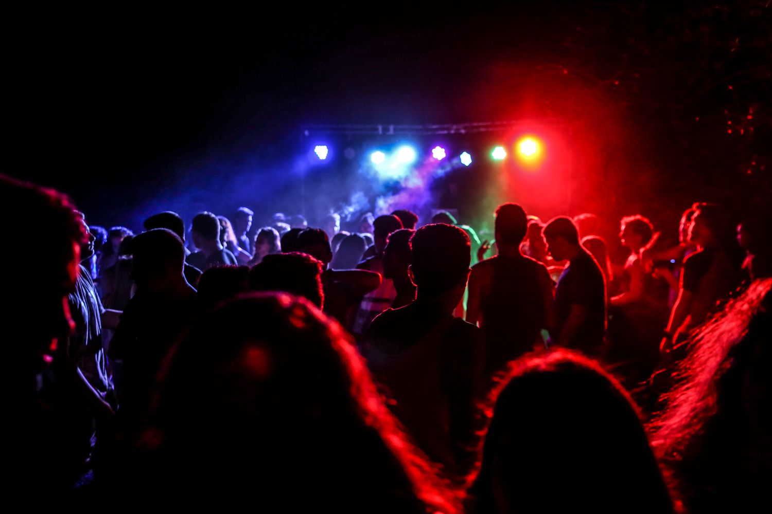 People dancing at a lively party under colorful lights