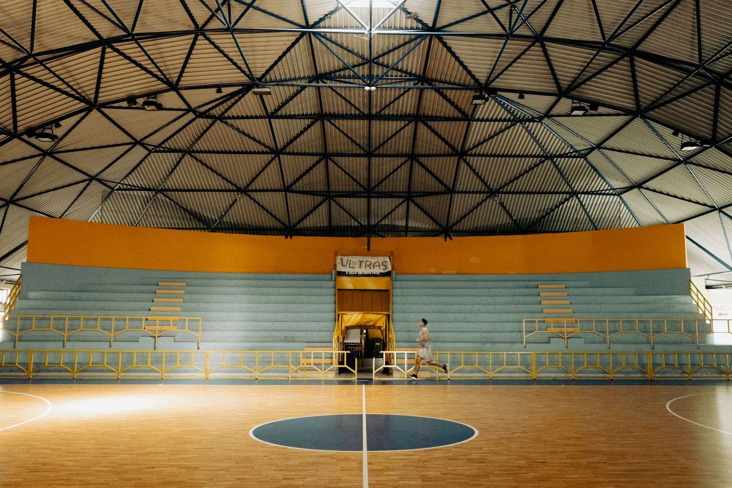 Empty bleachers inside a high school basketball gymnasium