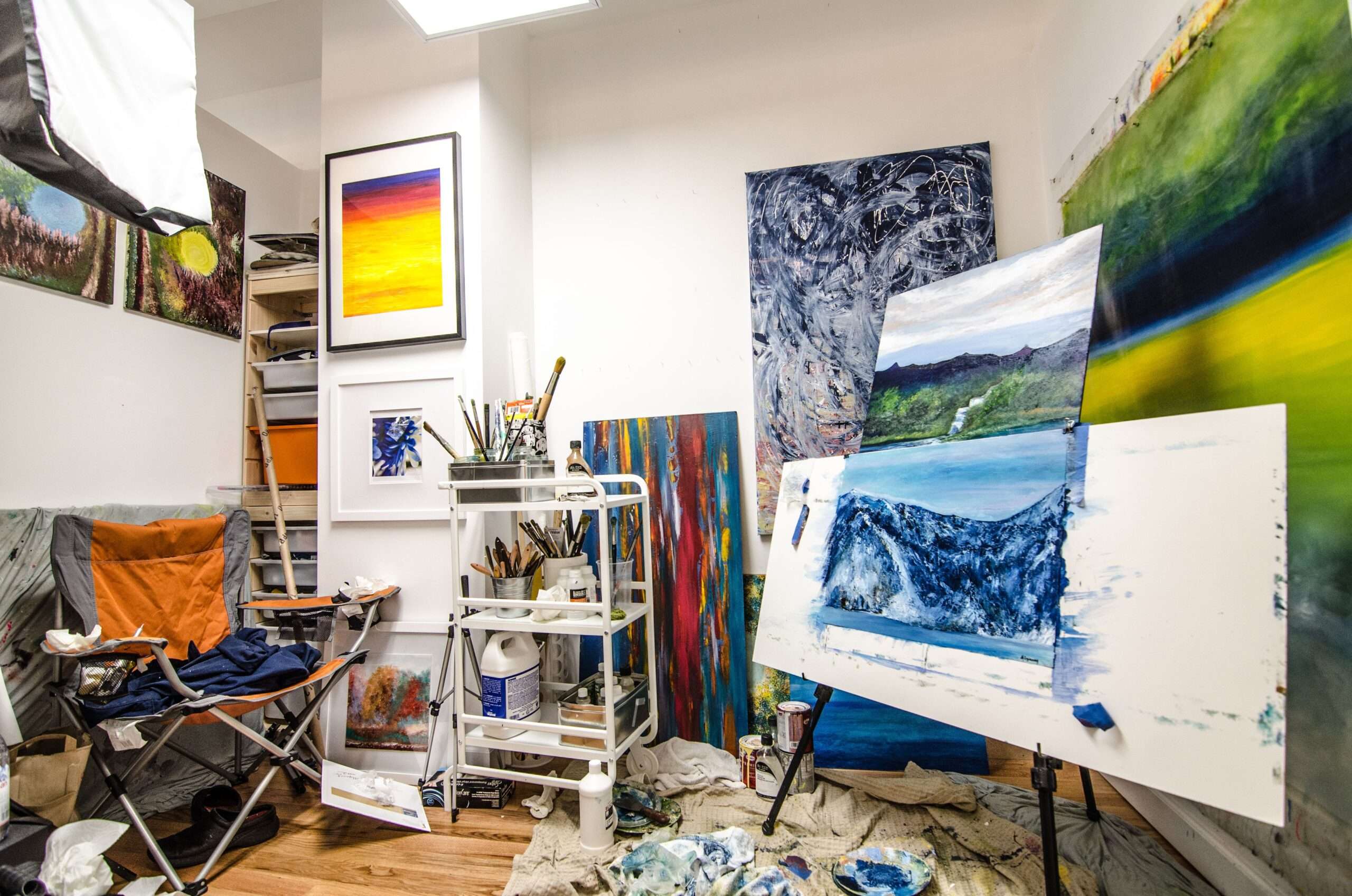 Paintings and brushes in an artist studio, representing the kind of visiting artist work supported by grant funding