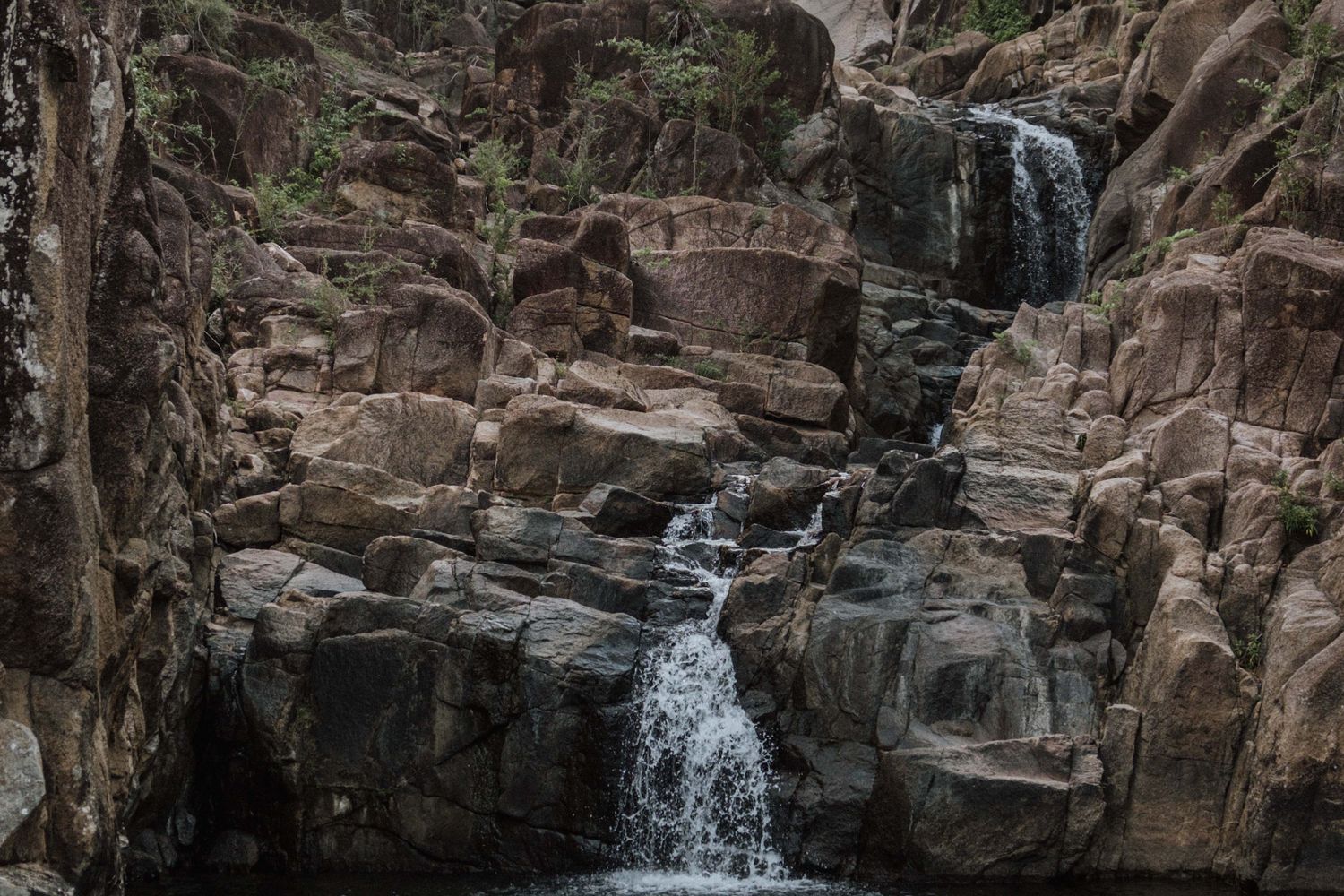 A waterfall cascading over rocks in a wooded Alabama park