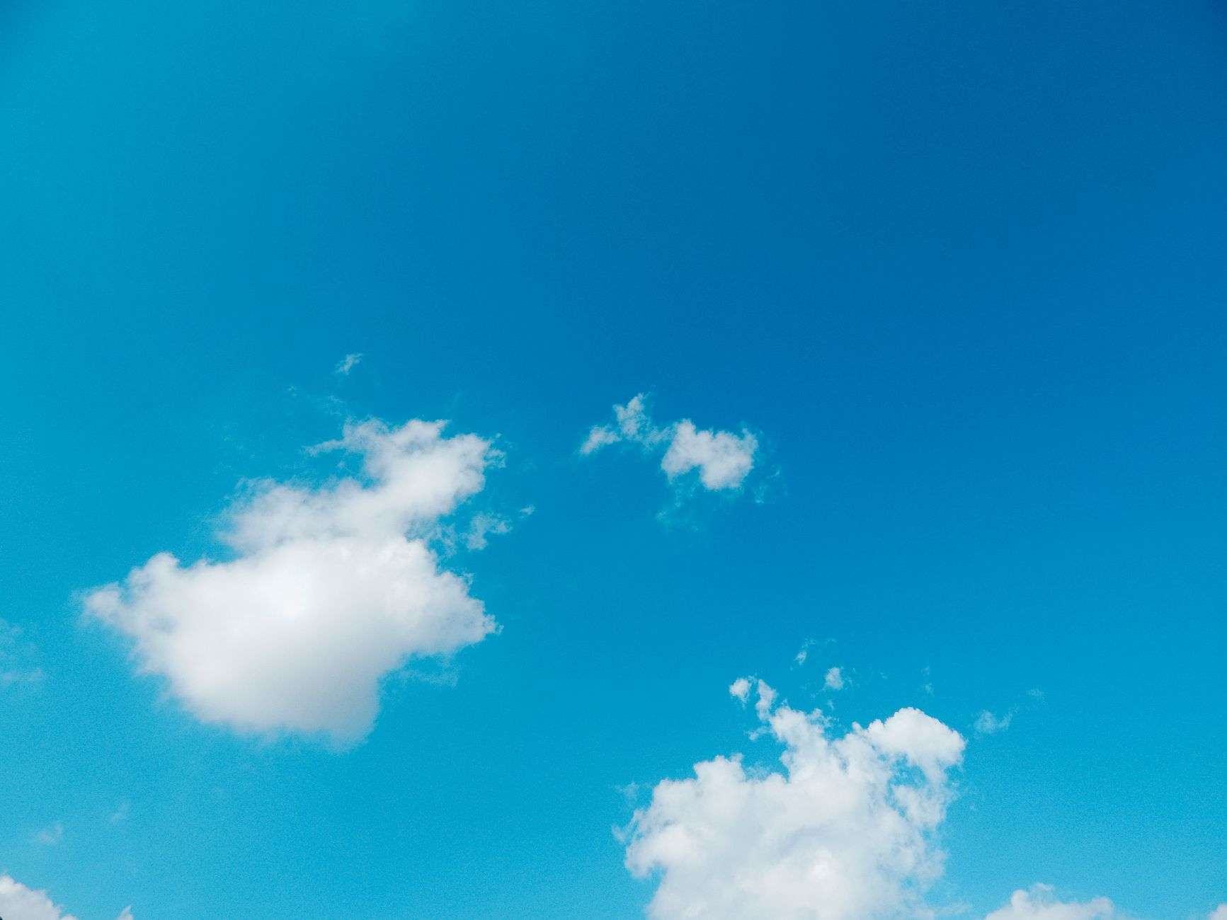 Clear blue sky with scattered clouds over a Gulf Coast landscape