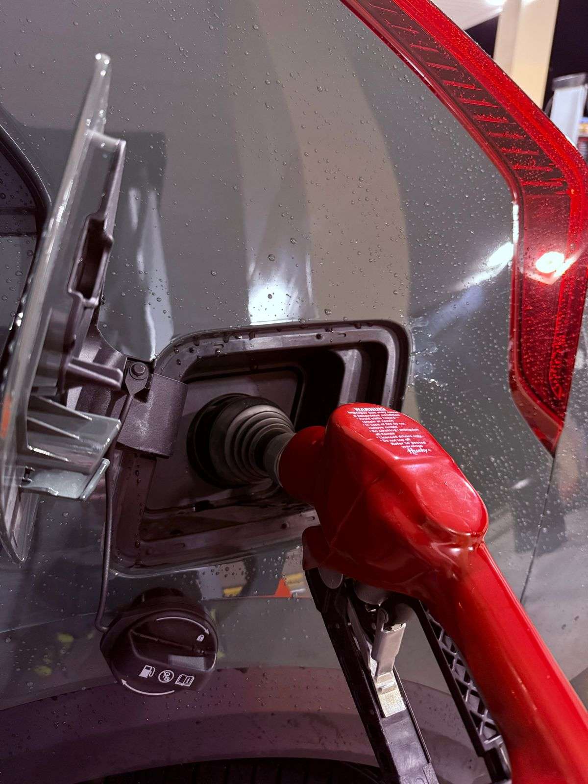 A motorist refueling a car at a gas station pump