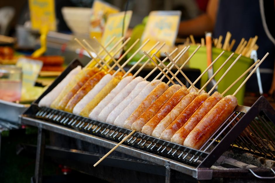 Grilled sausages cooking at an outdoor community festival