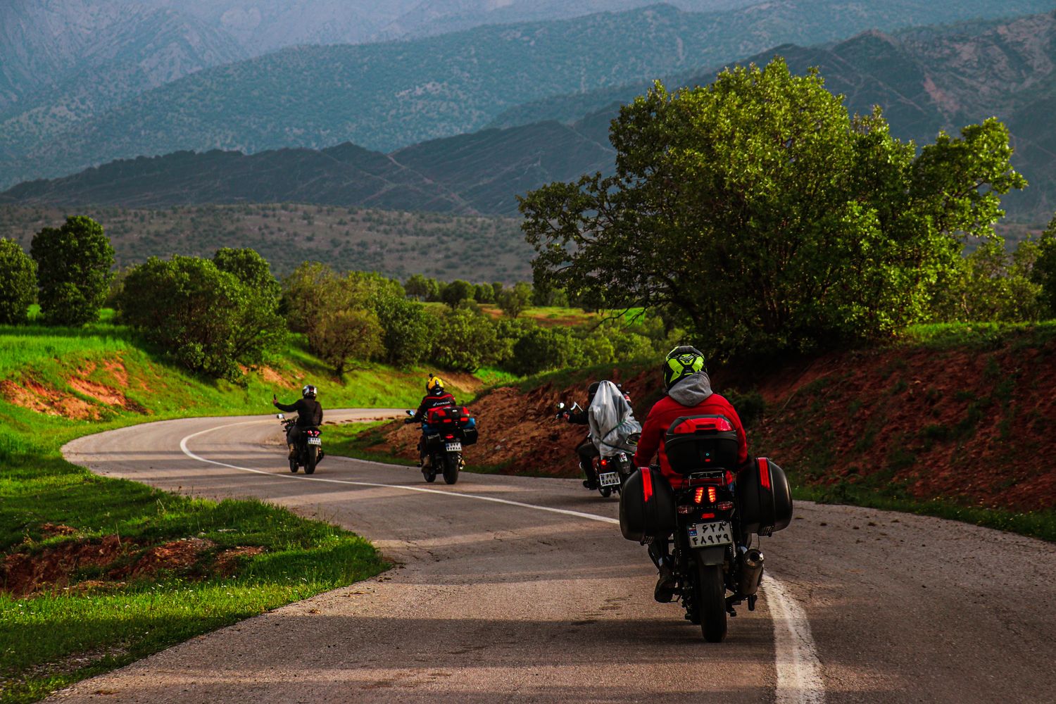Motorcyclists riding together down a country road during a group ride