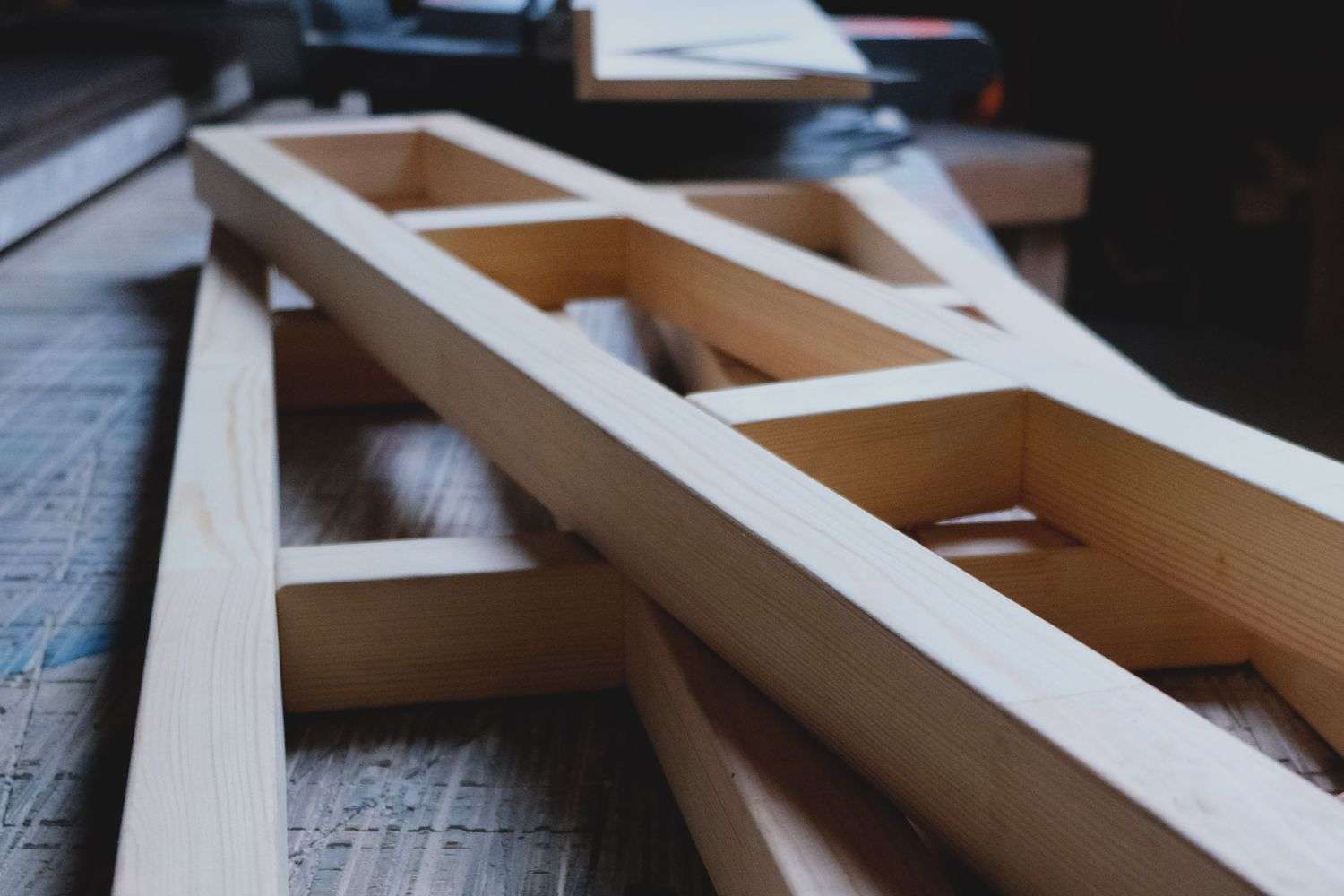 Carpenter framing a wood wall with hand tools in a workshop