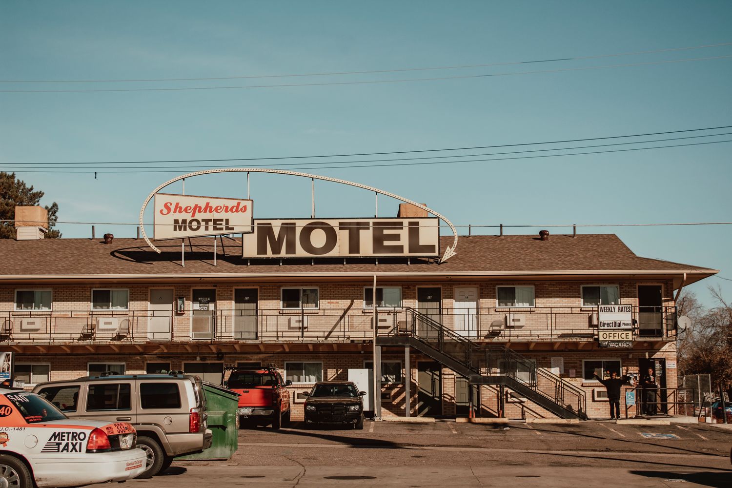 Exterior of a hotel with its parking lot in the foreground