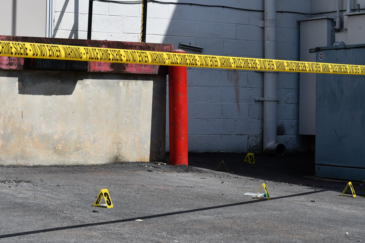 Yellow police tape marking a crime scene on a neighborhood street
