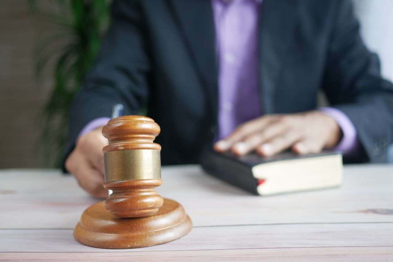 Close-up of a wooden gavel resting on a desk in a courtroom