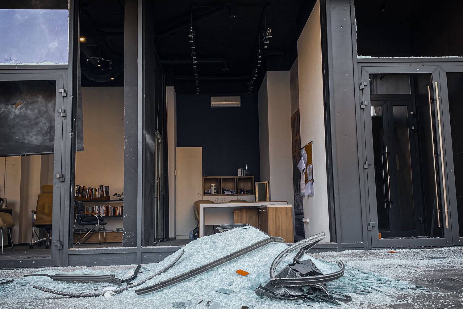 Damaged storefront with shattered glass after a car crashed into a Grand Bay business