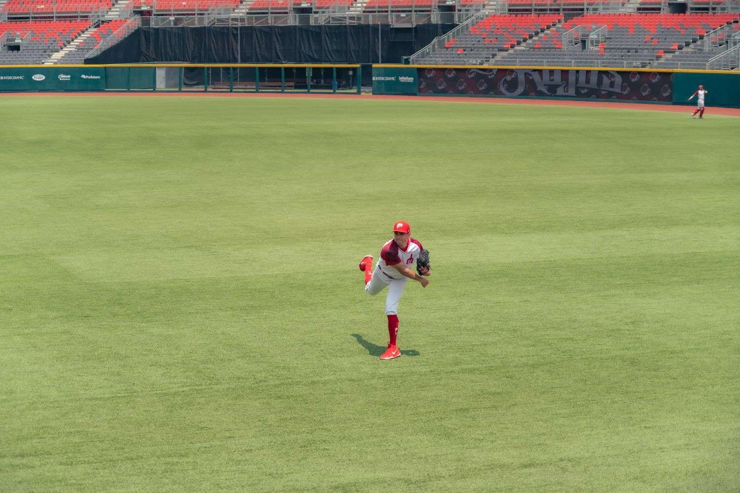 An empty baseball stadium field with infield dirt and green outfield