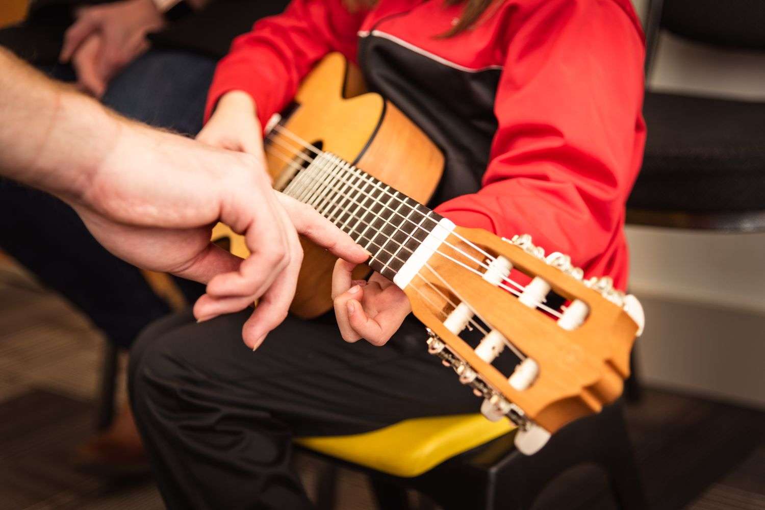 Child practicing guitar during a youth club music program