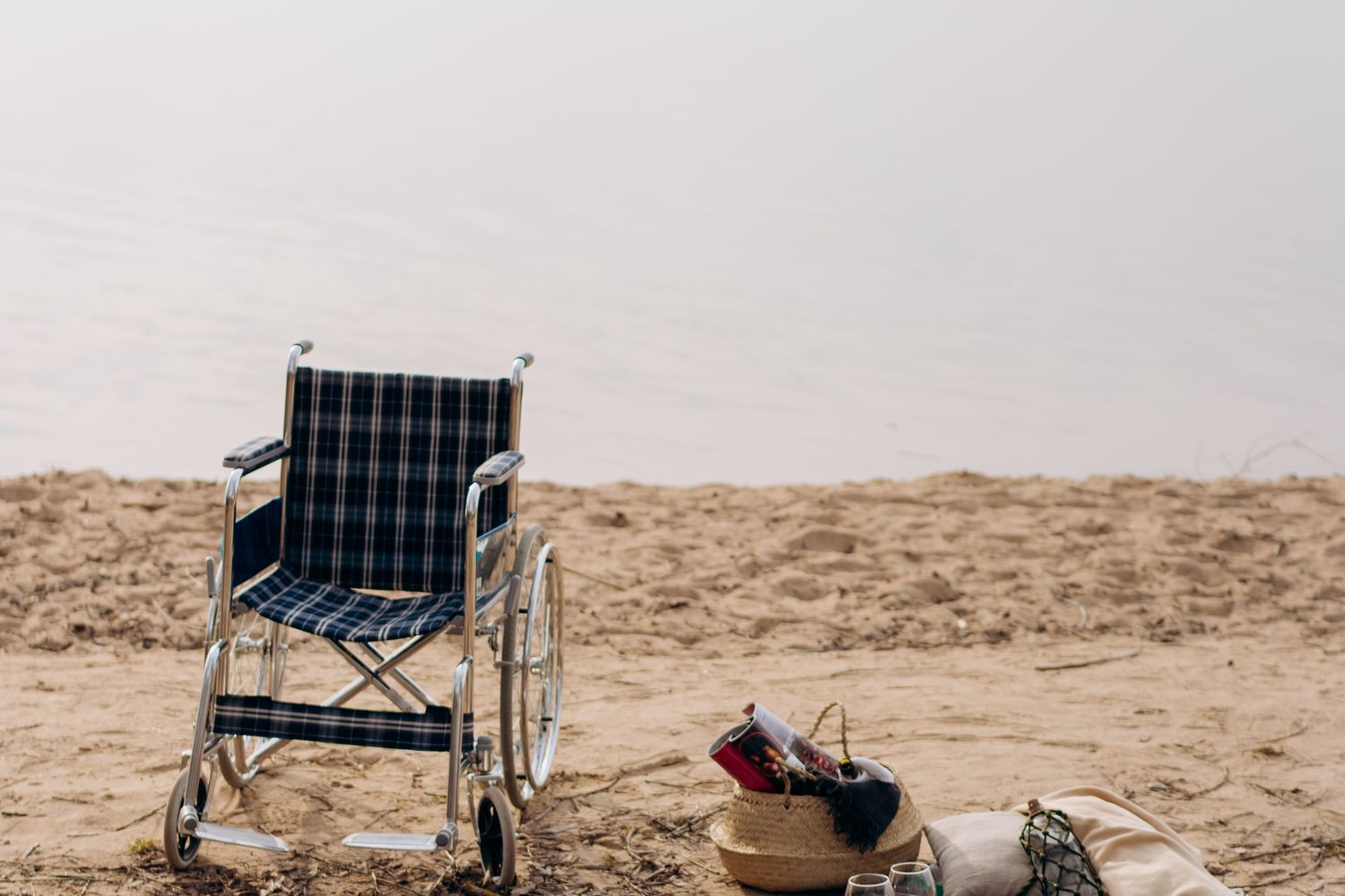 A beach access mat laid across sand for wheelchair users