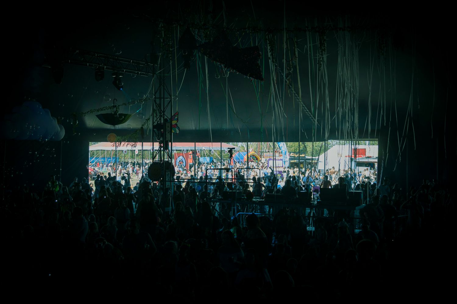 Festival crowd on the beach in front of a large concert stage at sunset