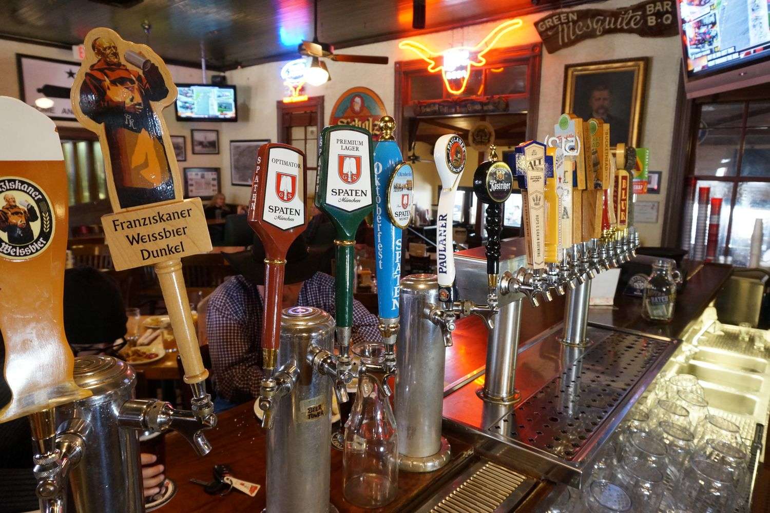 The interior of a neighborhood bar with flat-screen televisions mounted on the wall