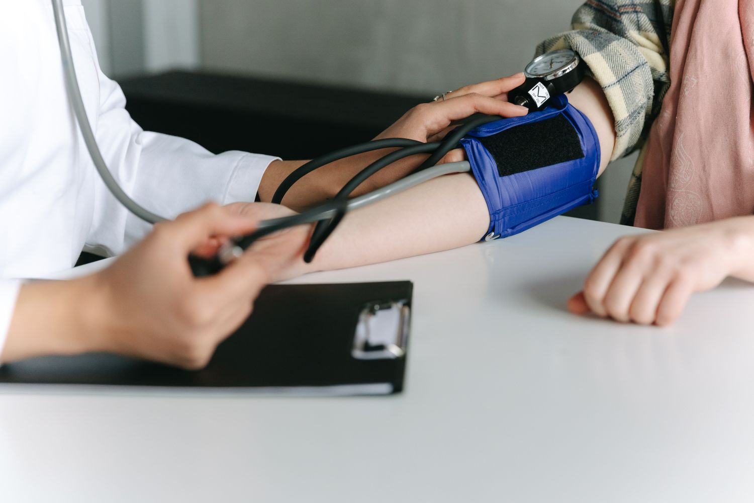 Doctor checking a patient's blood pressure with a cuff