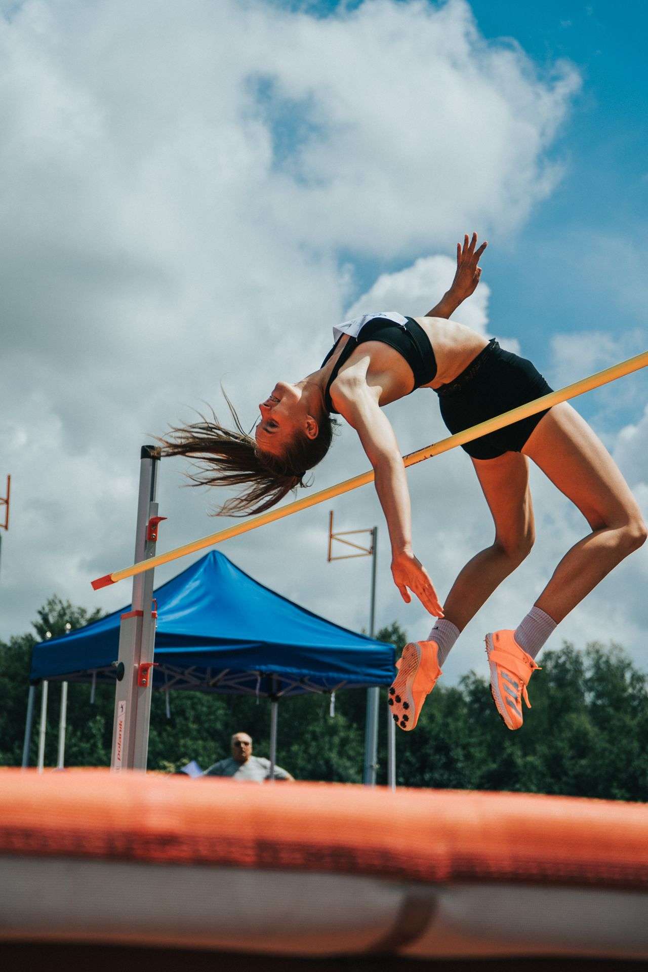 An athlete arches over the bar during a high jump competition