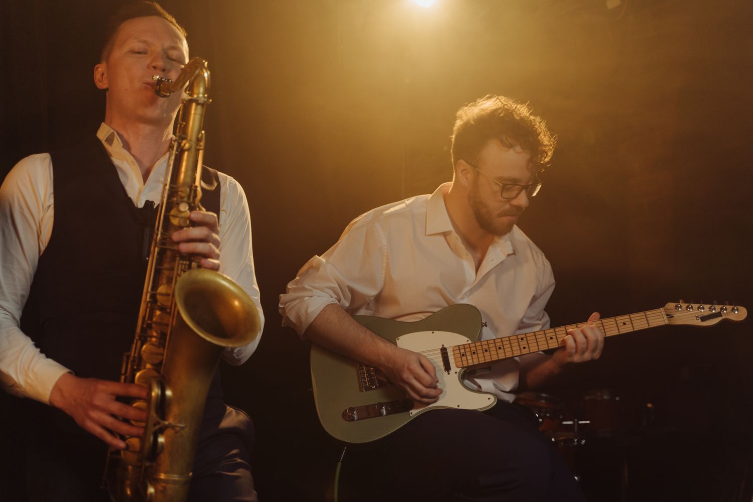 Two musicians performing improvised music on stage, saxophone and bass