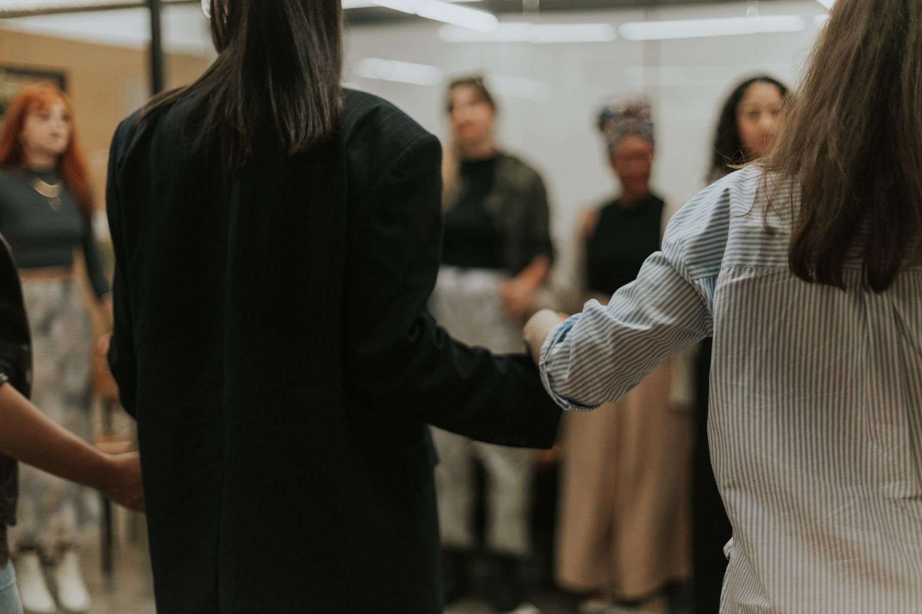 A group of people joining hands in a gesture of mutual support