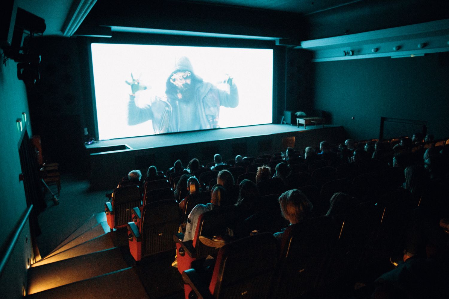 Dark theater auditorium with a glowing movie screen