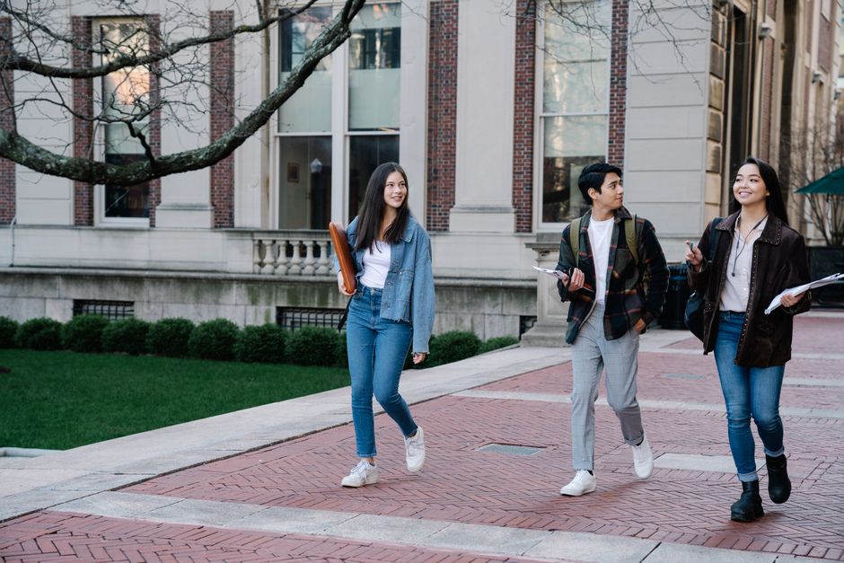 Students walking across a university campus quad on a sunny day
