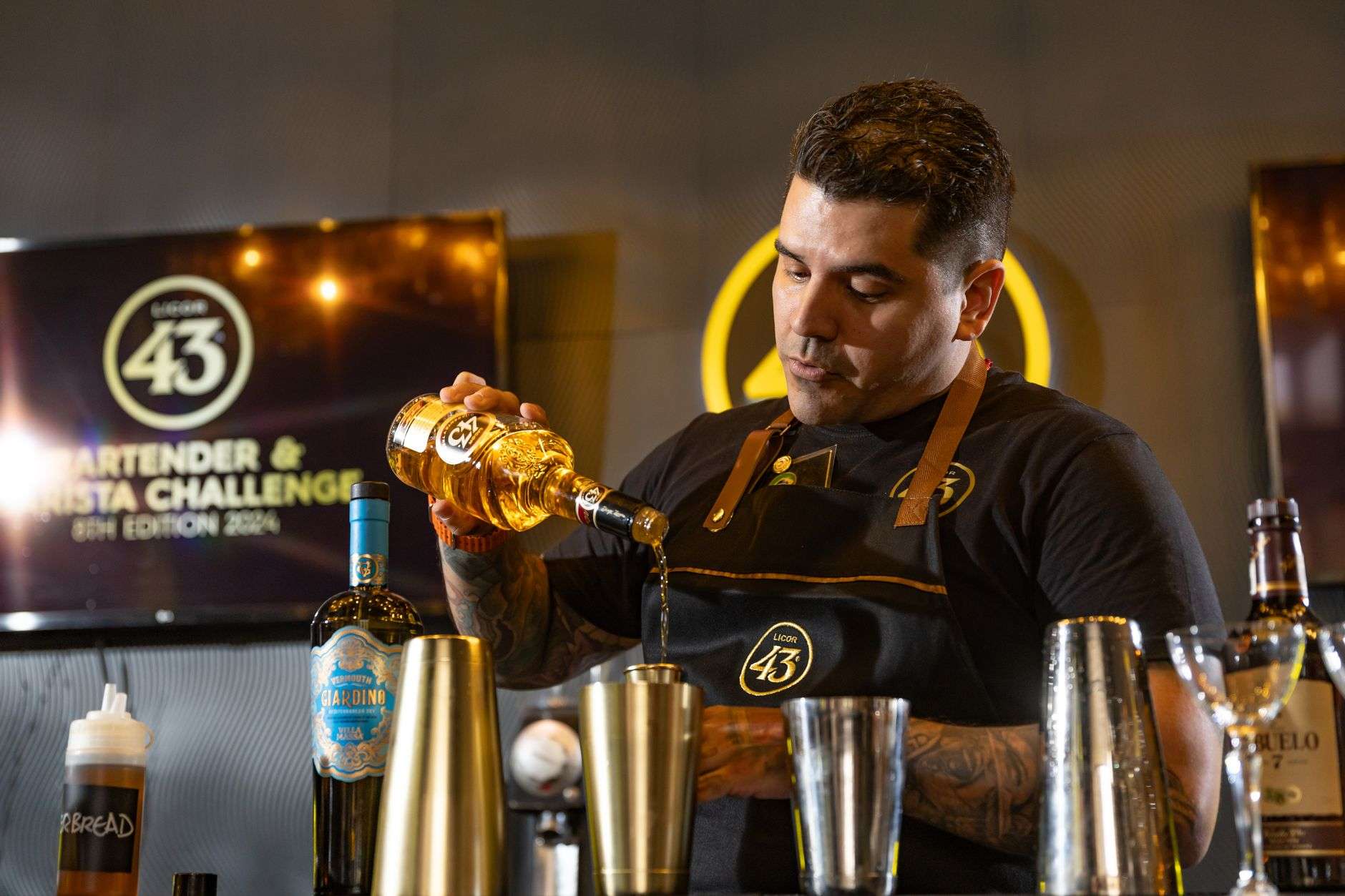 Bartender pouring a cocktail during a mixology competition at The Hope Farm in Fairhope