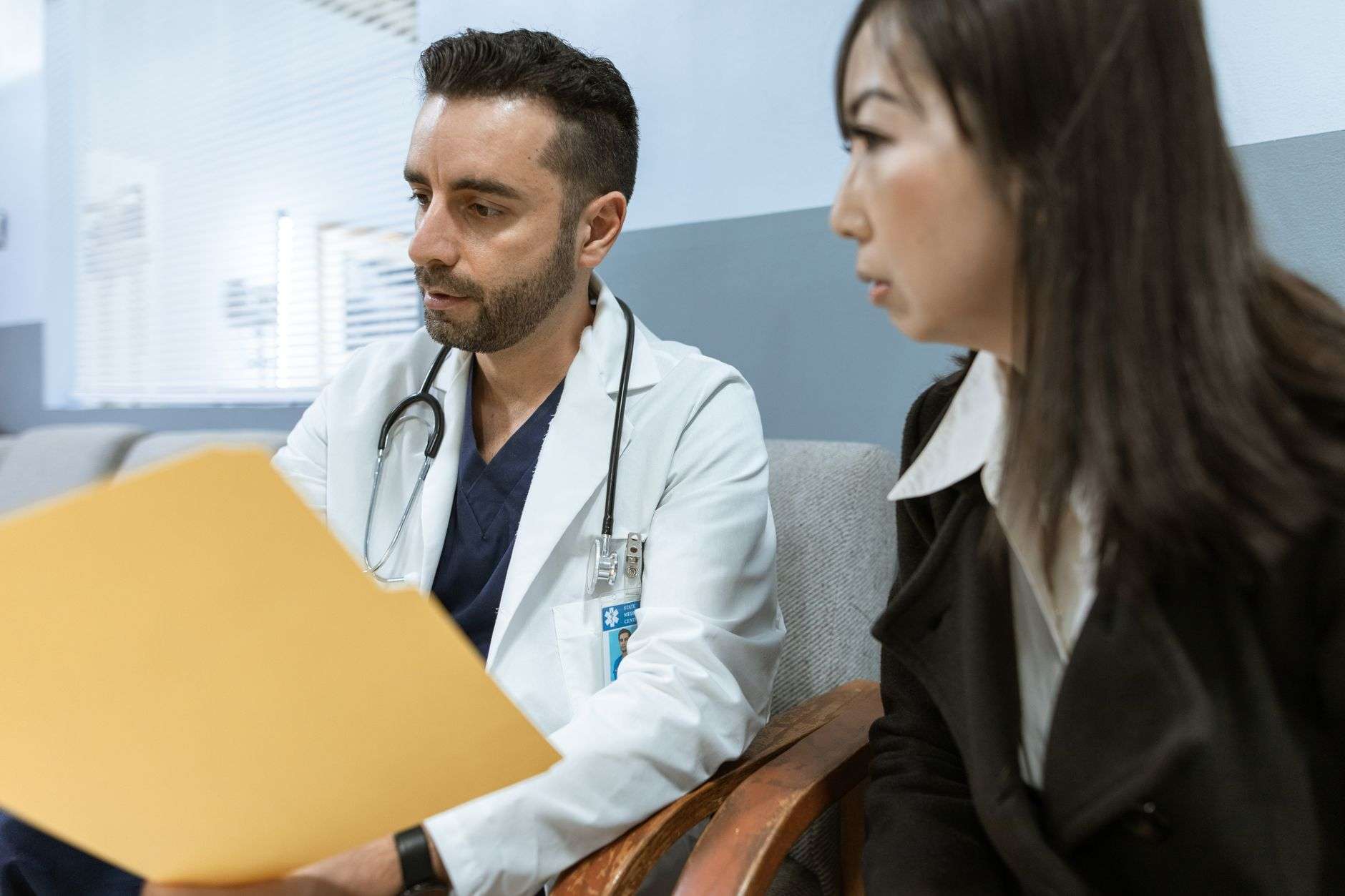 Doctor in white coat speaking with a patient during an office consultation