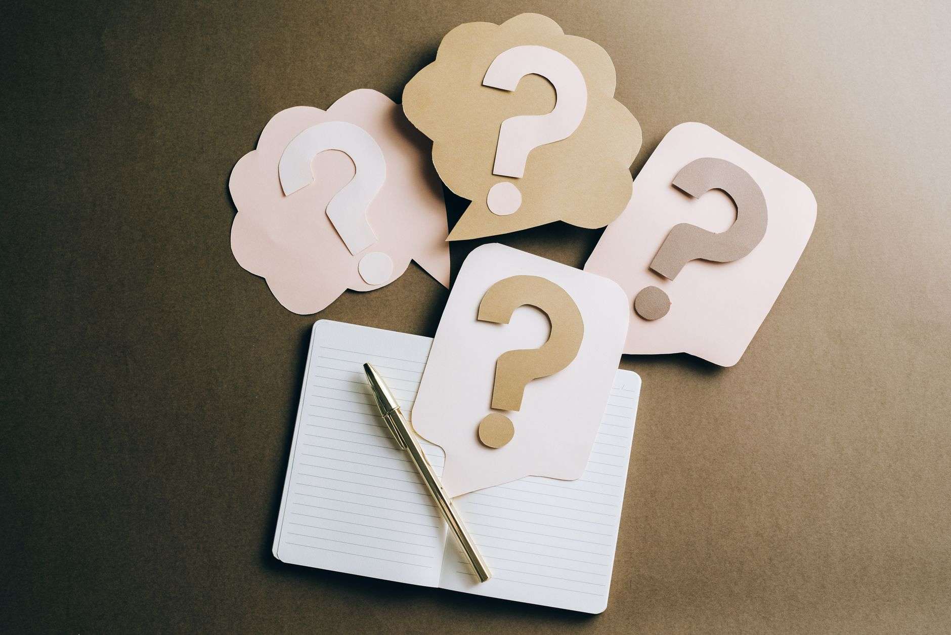 Question mark cutouts on a notebook representing a business trivia quiz