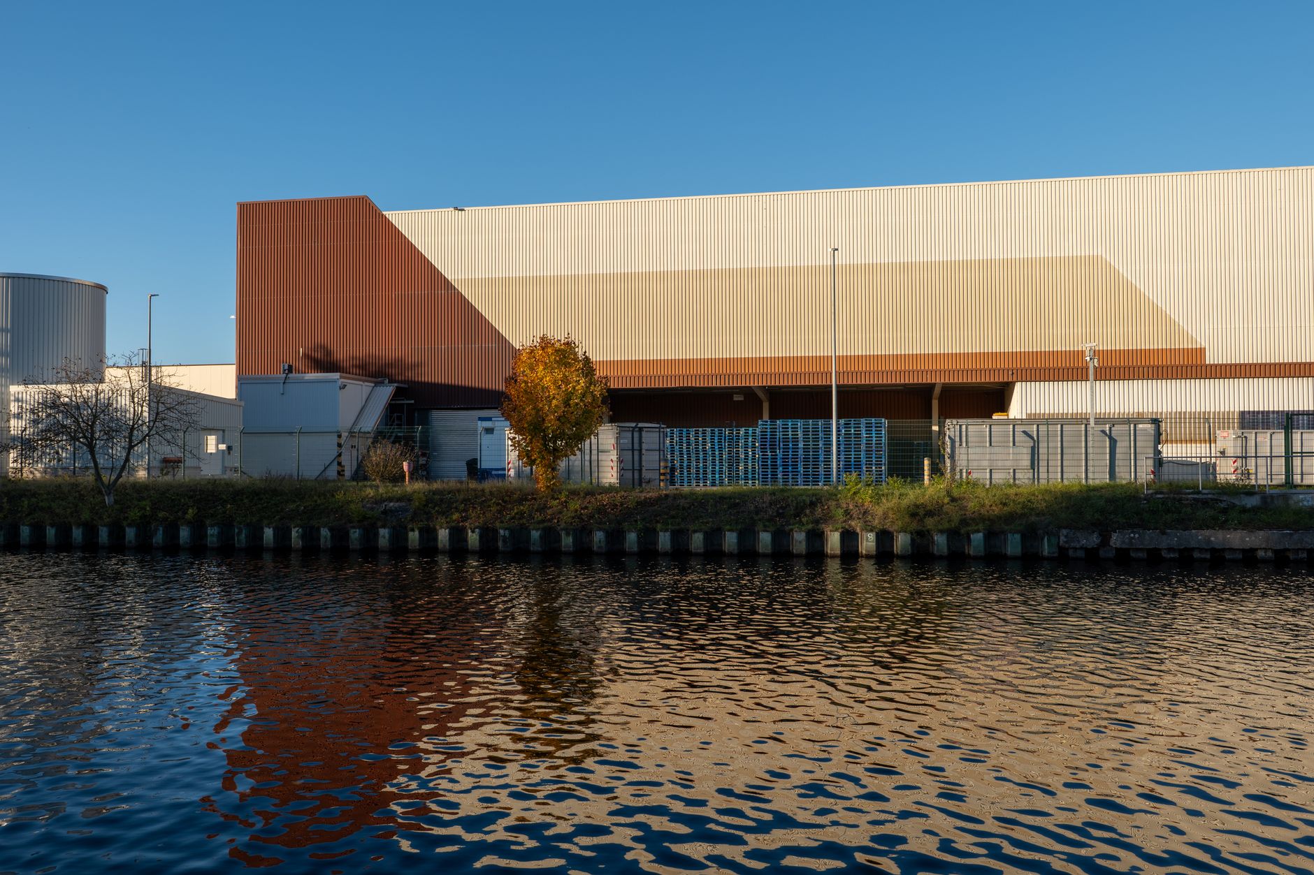 Industrial warehouse building and storage tanks along an urban waterway
