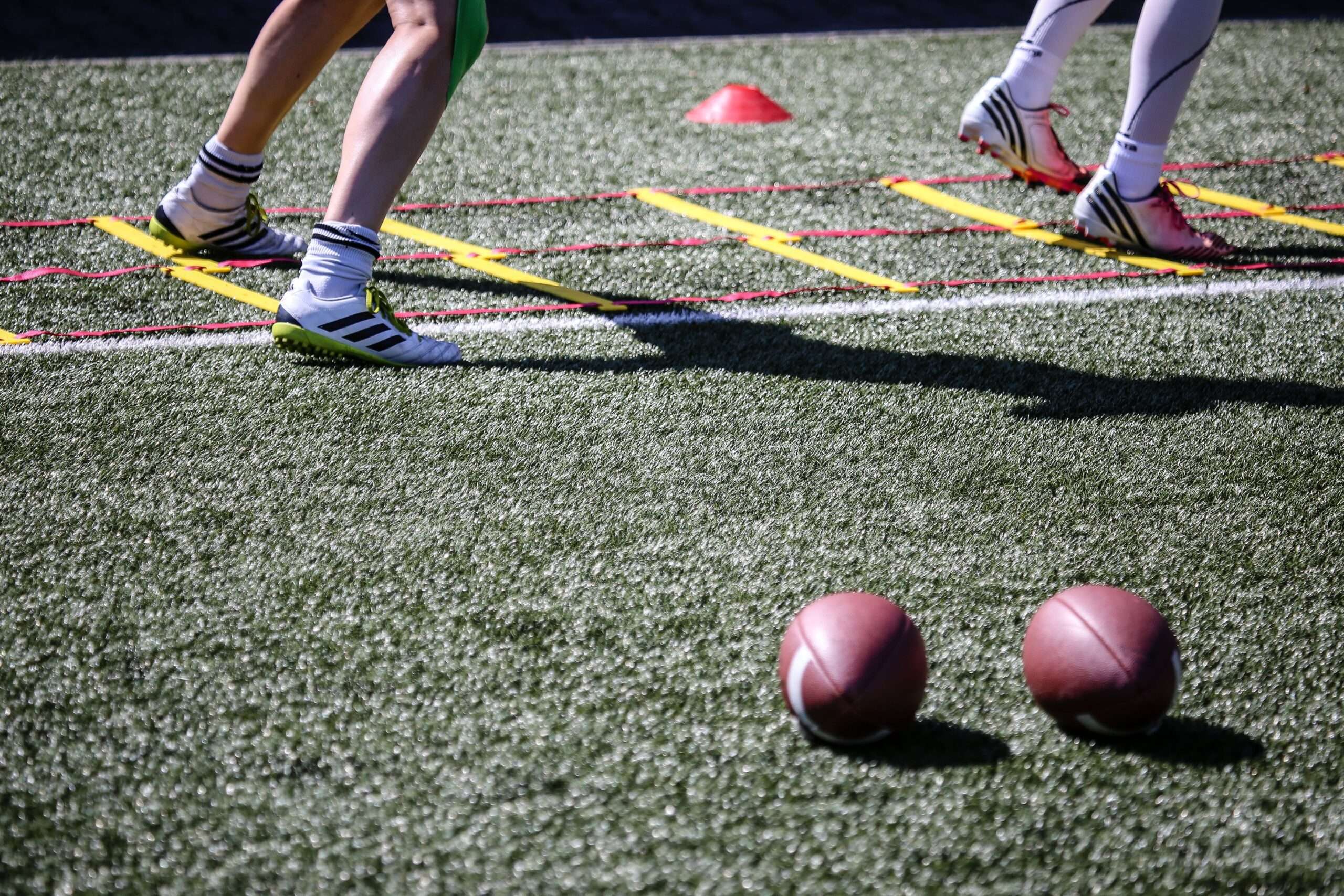 College football players running agility drills during fall practice