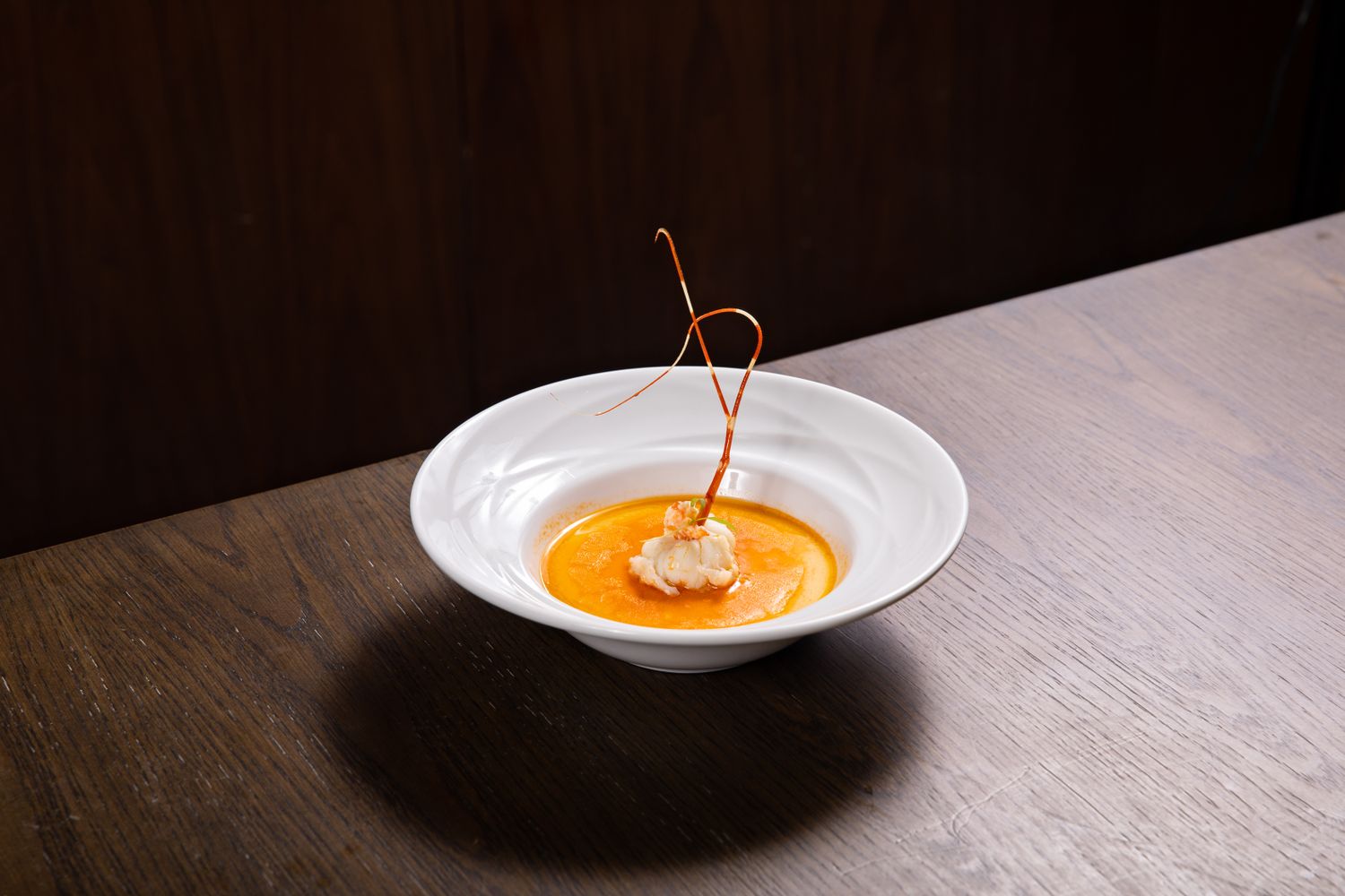 A steaming bowl of creamy crawfish bisque topped with a stuffed crawfish head