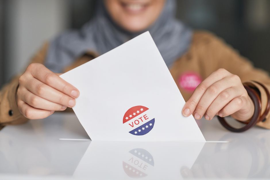 Voter placing a ballot into a ballot box