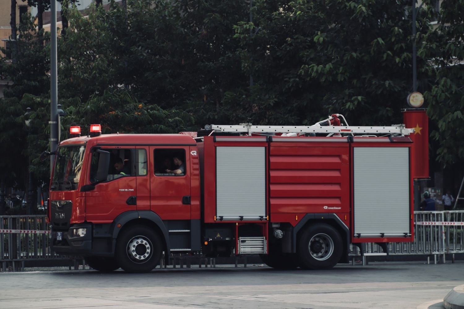 Red fire truck traveling down a road with lights on