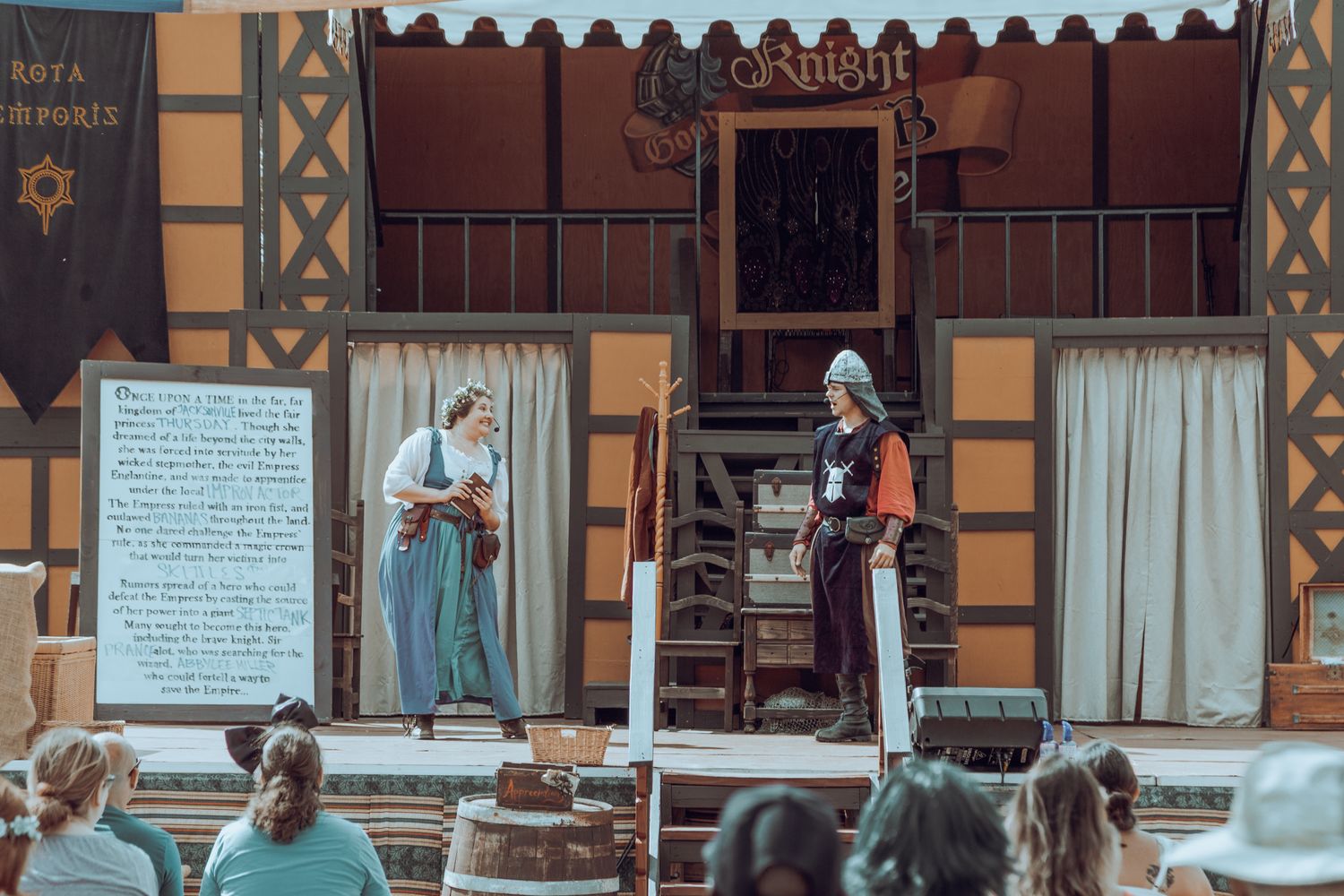 Two costumed performers act out a scene on a community theater stage