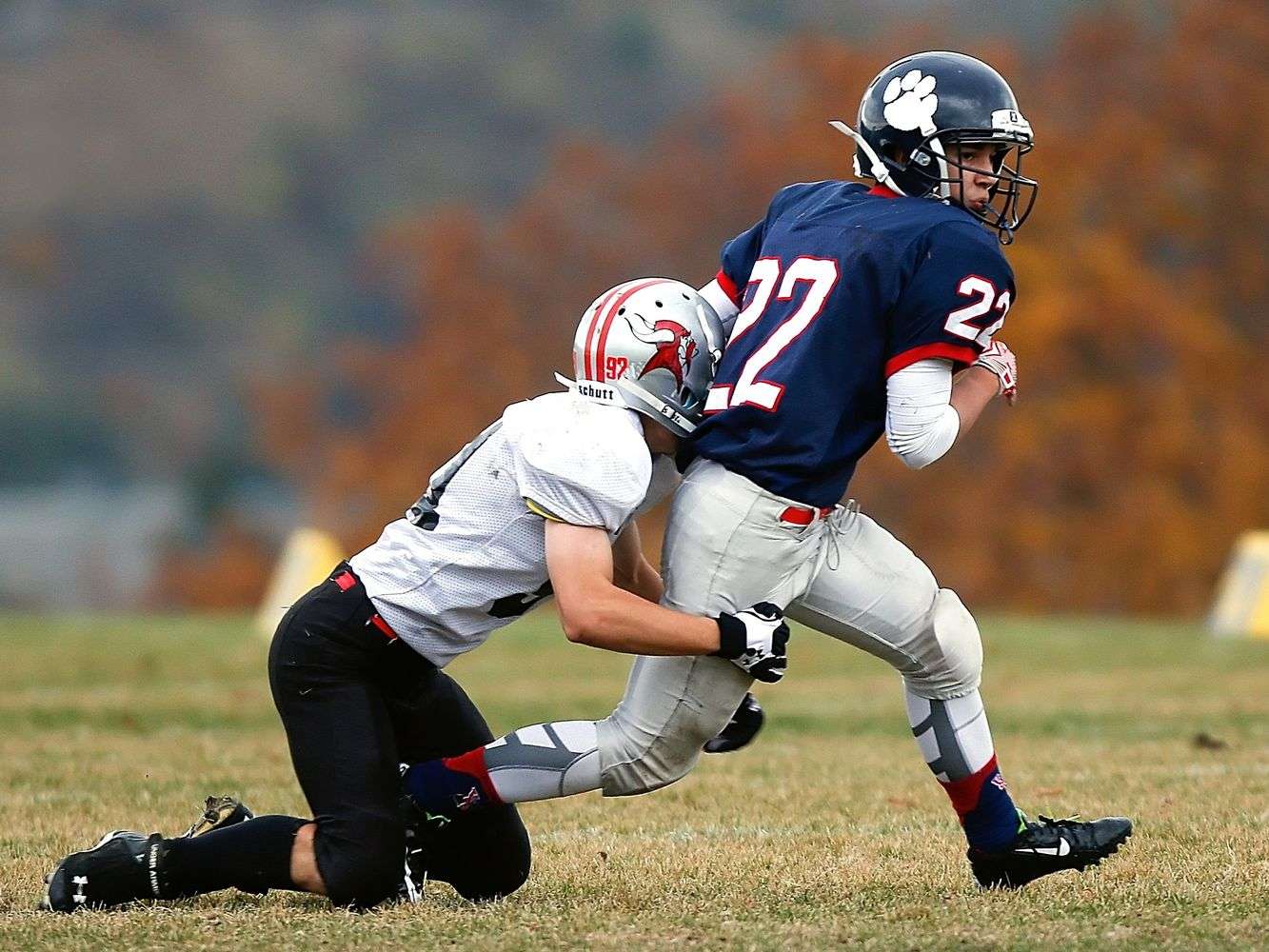 High school football player making a tackle during a game