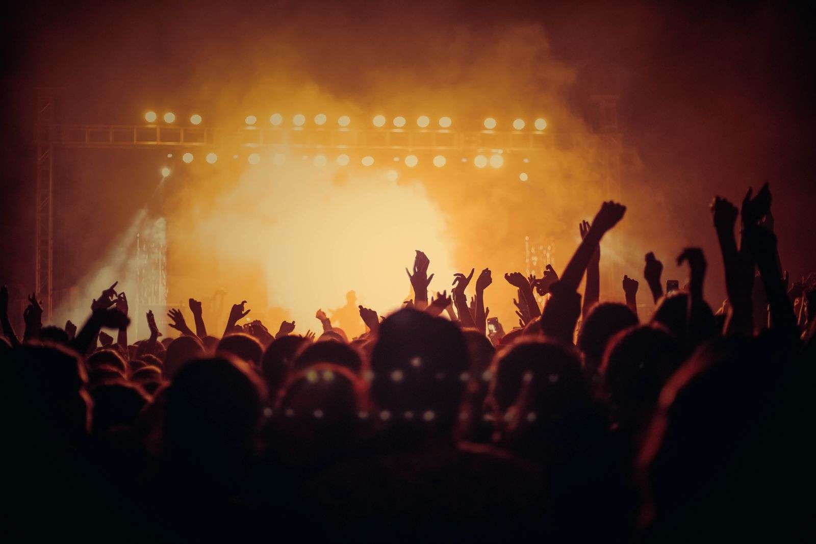 Stage lights beaming over a crowd at an outdoor concert