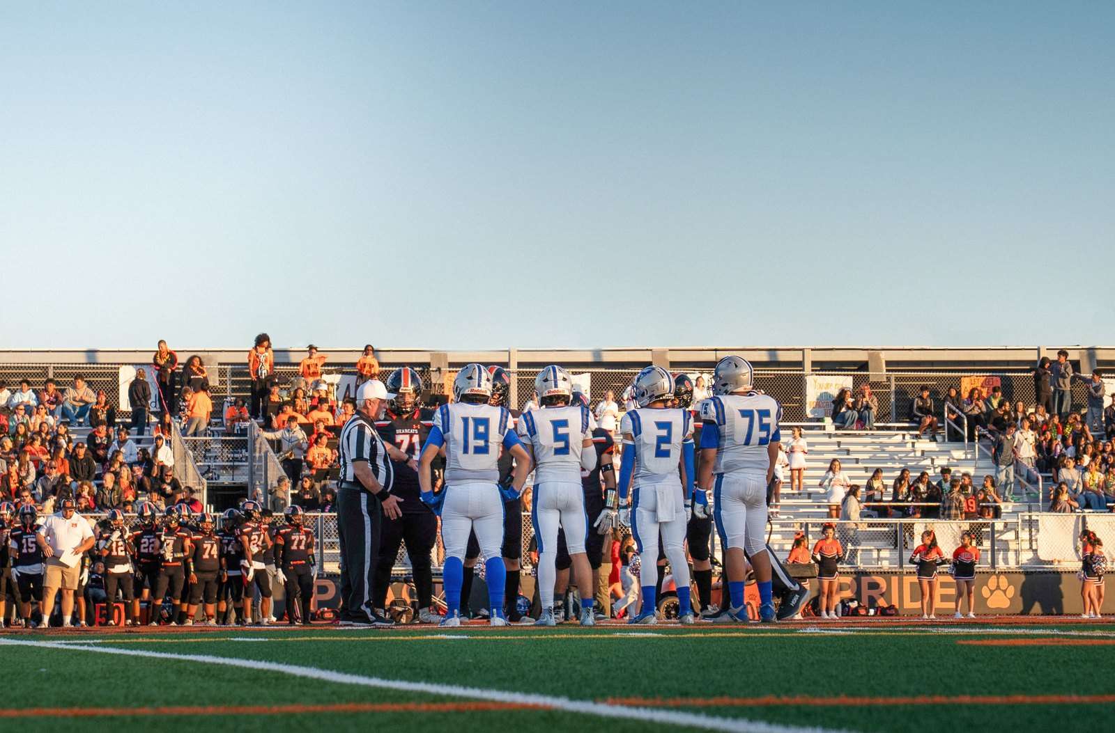 Spectators watch from the bleachers during a high school football game
