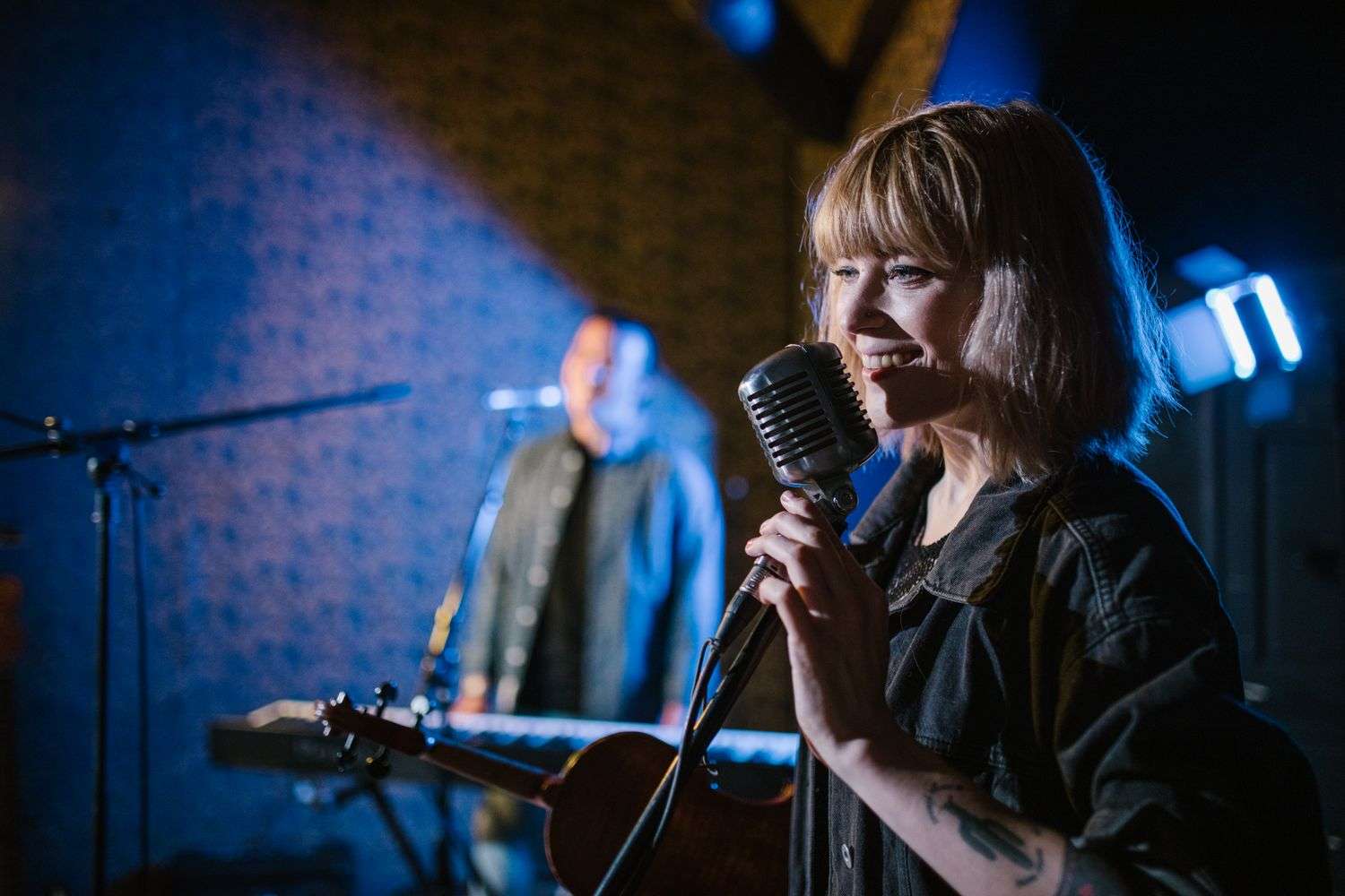 A female singer performing on stage with a live band behind her