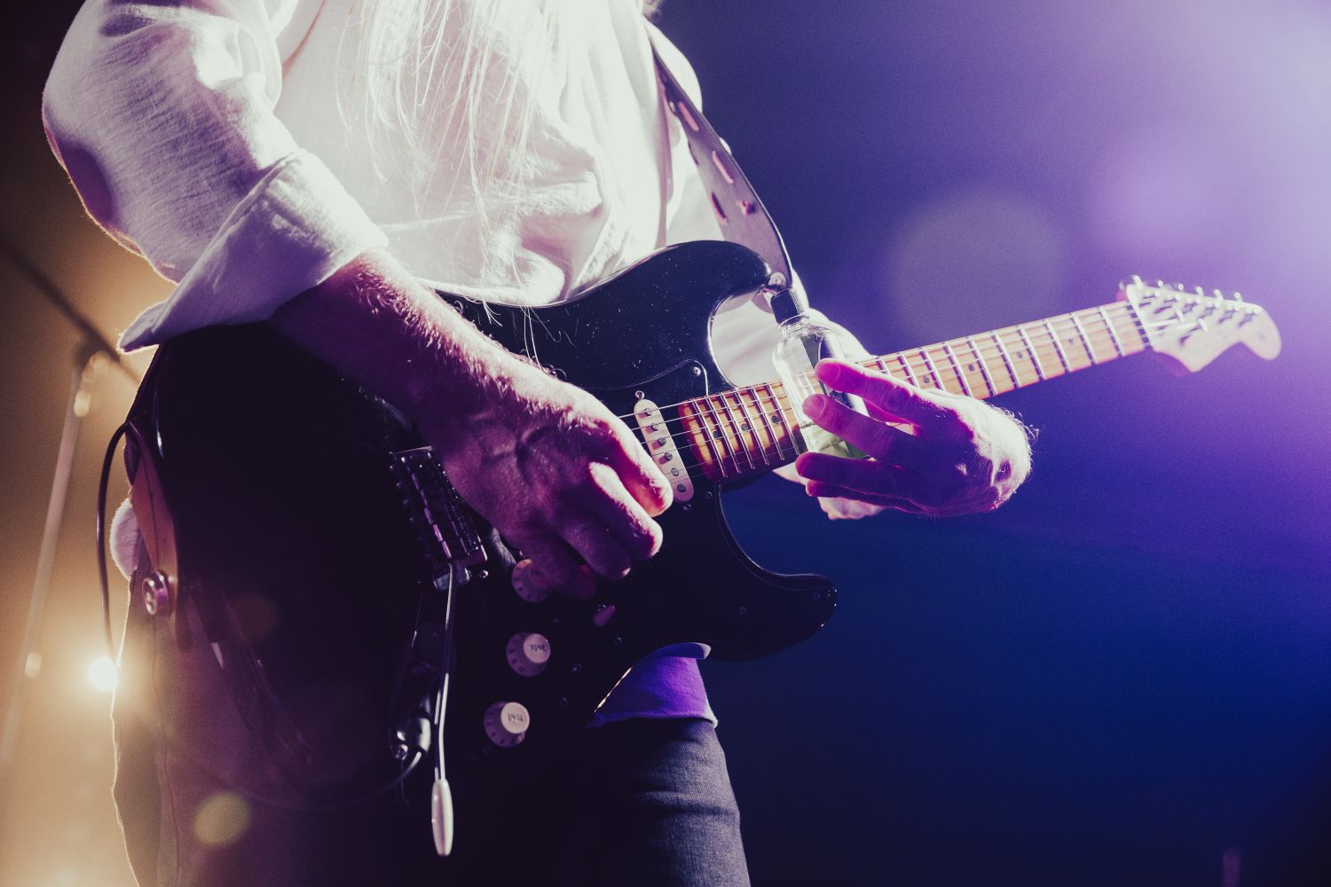 Guitarist leading a blues rock band during a live club performance