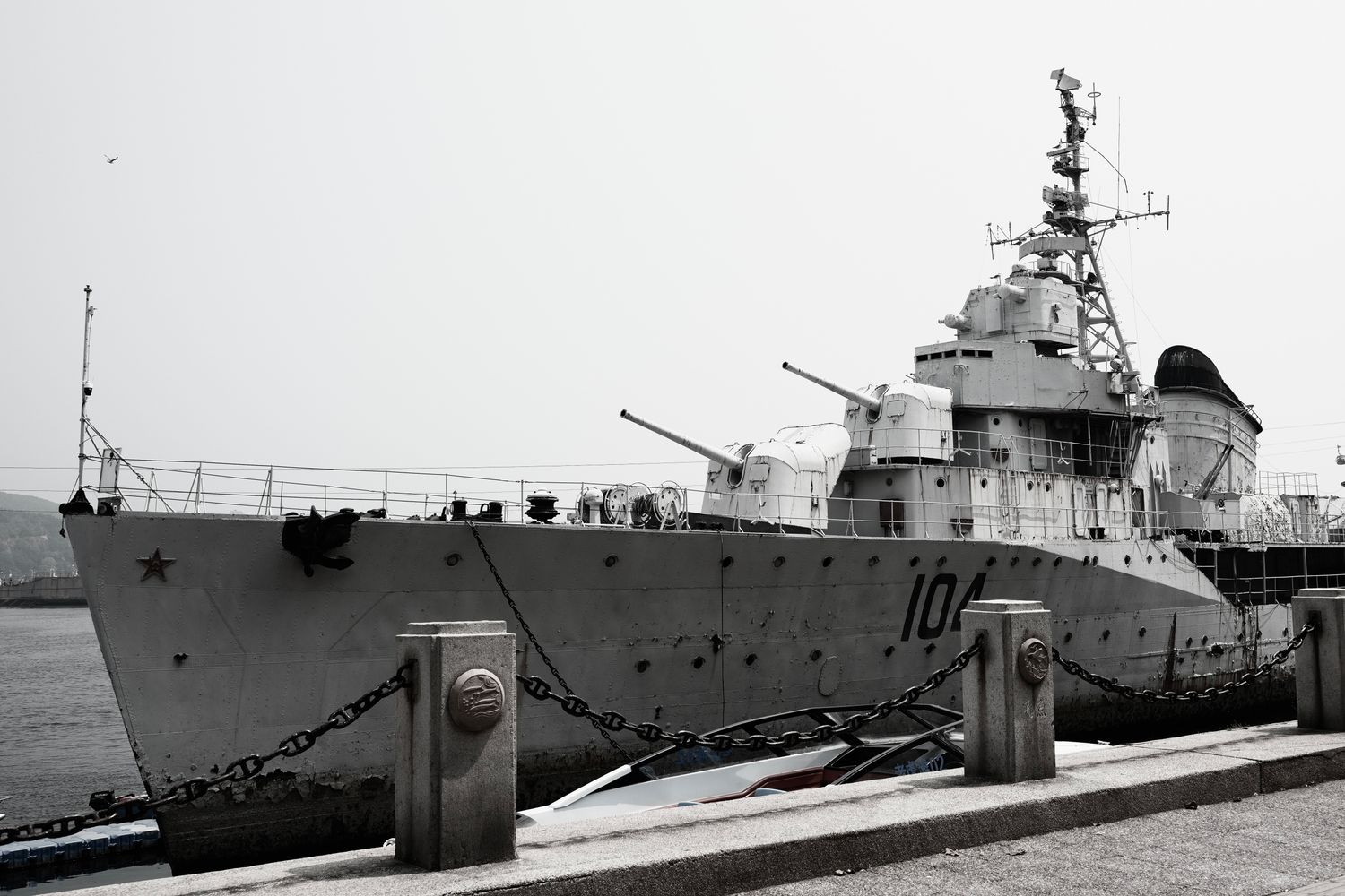 Gray Navy warship moored at a port terminal