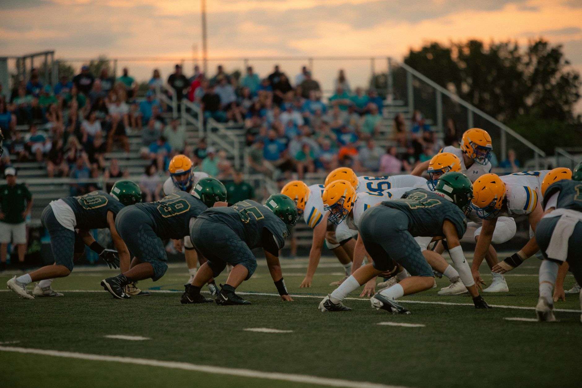 Players competing during a high school football game under stadium lights