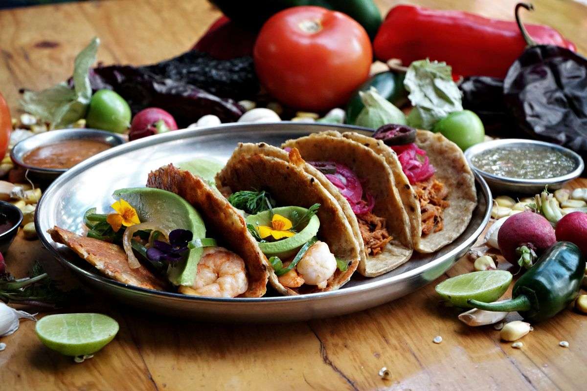 A platter of colorful Mexican tacos topped with fresh ingredients