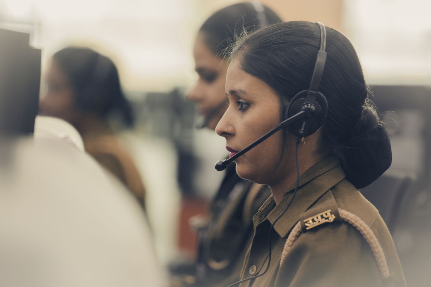 A 911 dispatcher works a call while wearing a communications headset