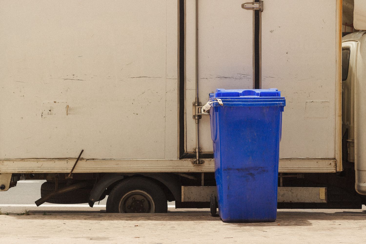 A sanitation truck collects trash along a residential street