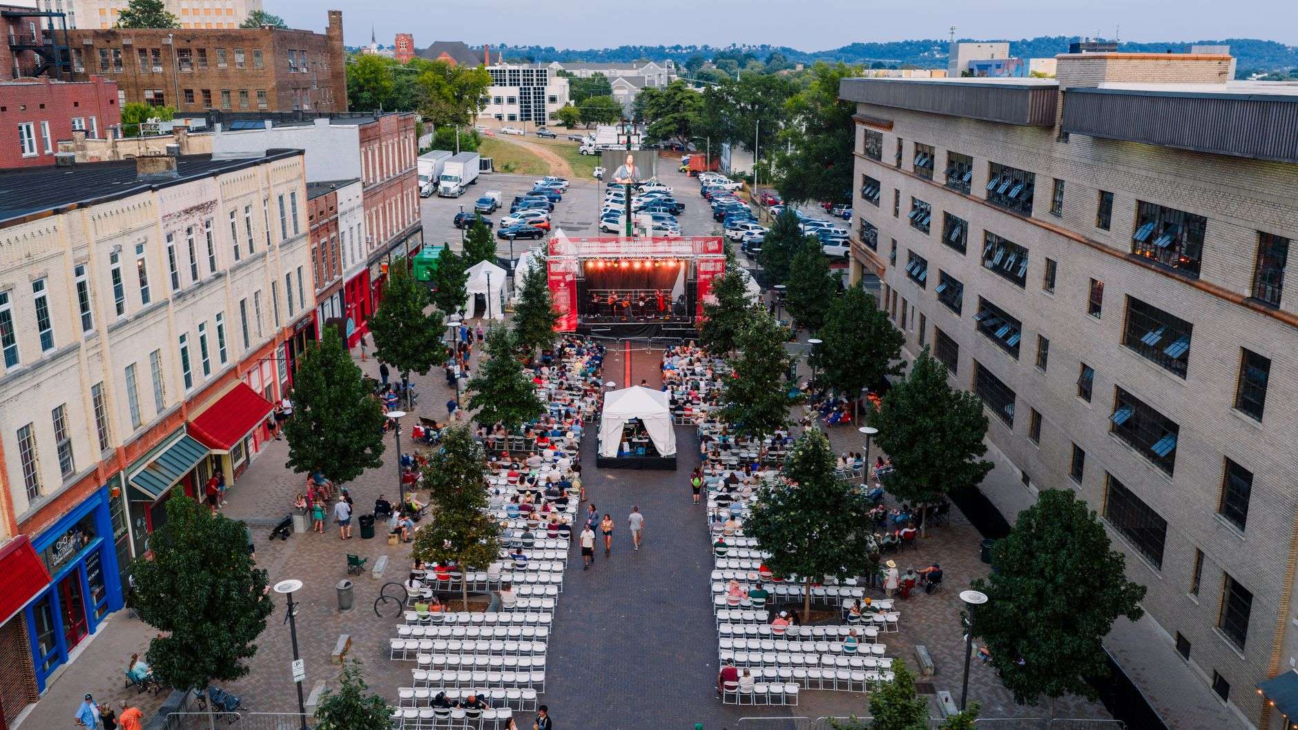 People gathered at an evening downtown street festival with lights
